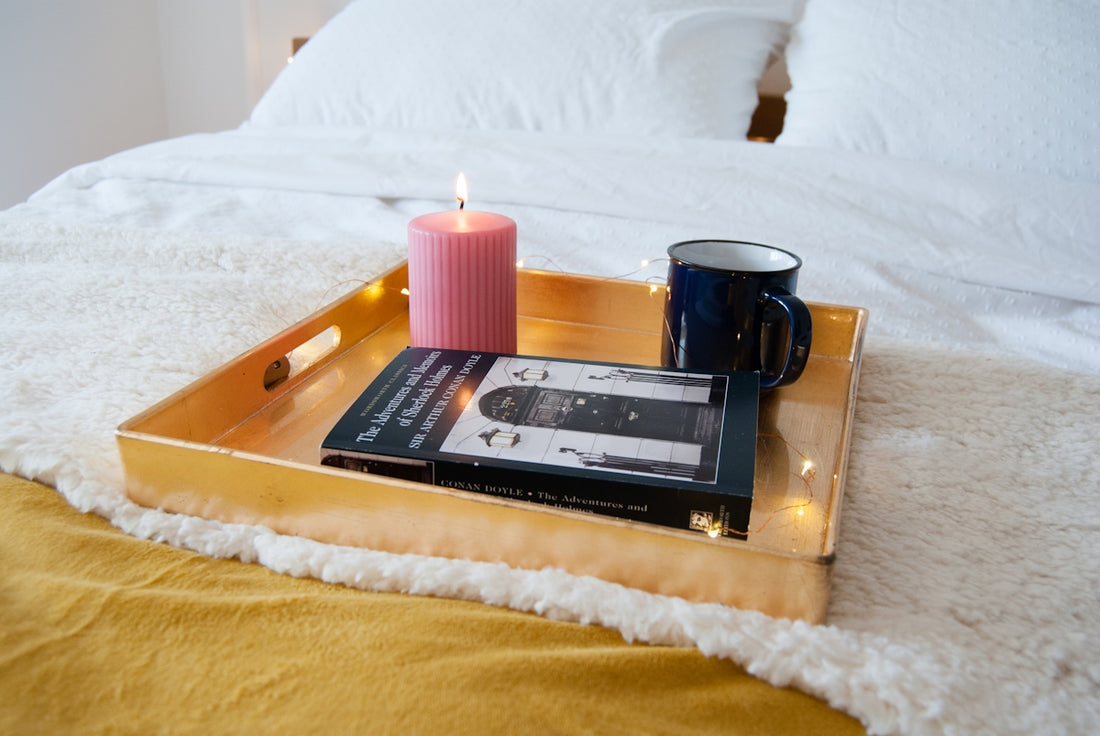 a candle and a book on a bed