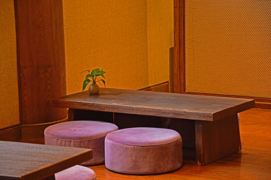 a wooden table with two stools and a small potted plant
