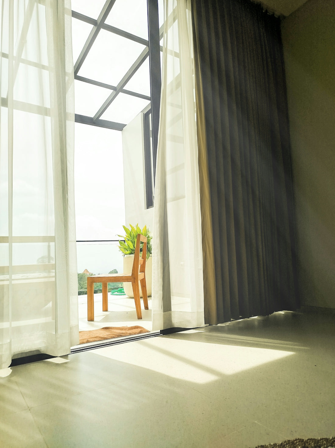 Sunlight streams through a balcony door onto floor.
