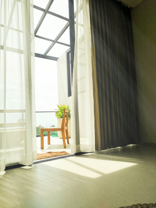 Sunlight streams through a balcony door onto floor.